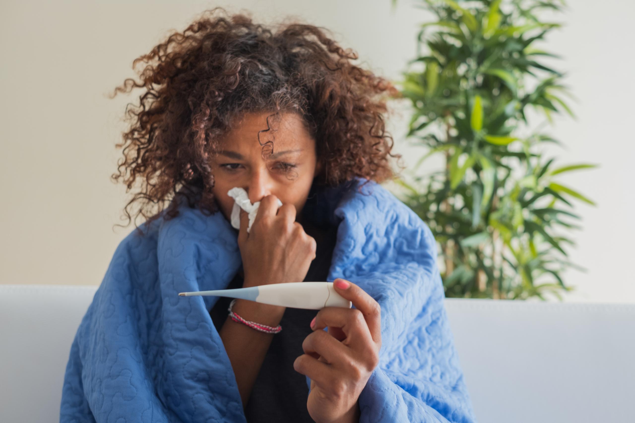 sick woman taking temperature