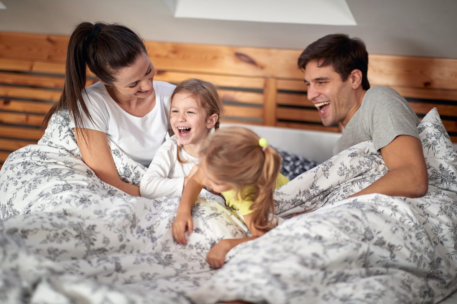family laughing in bed