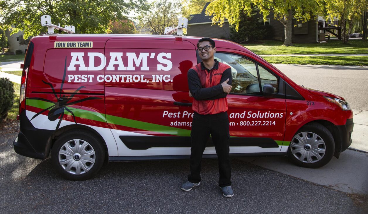 pest control professional standing by adams van