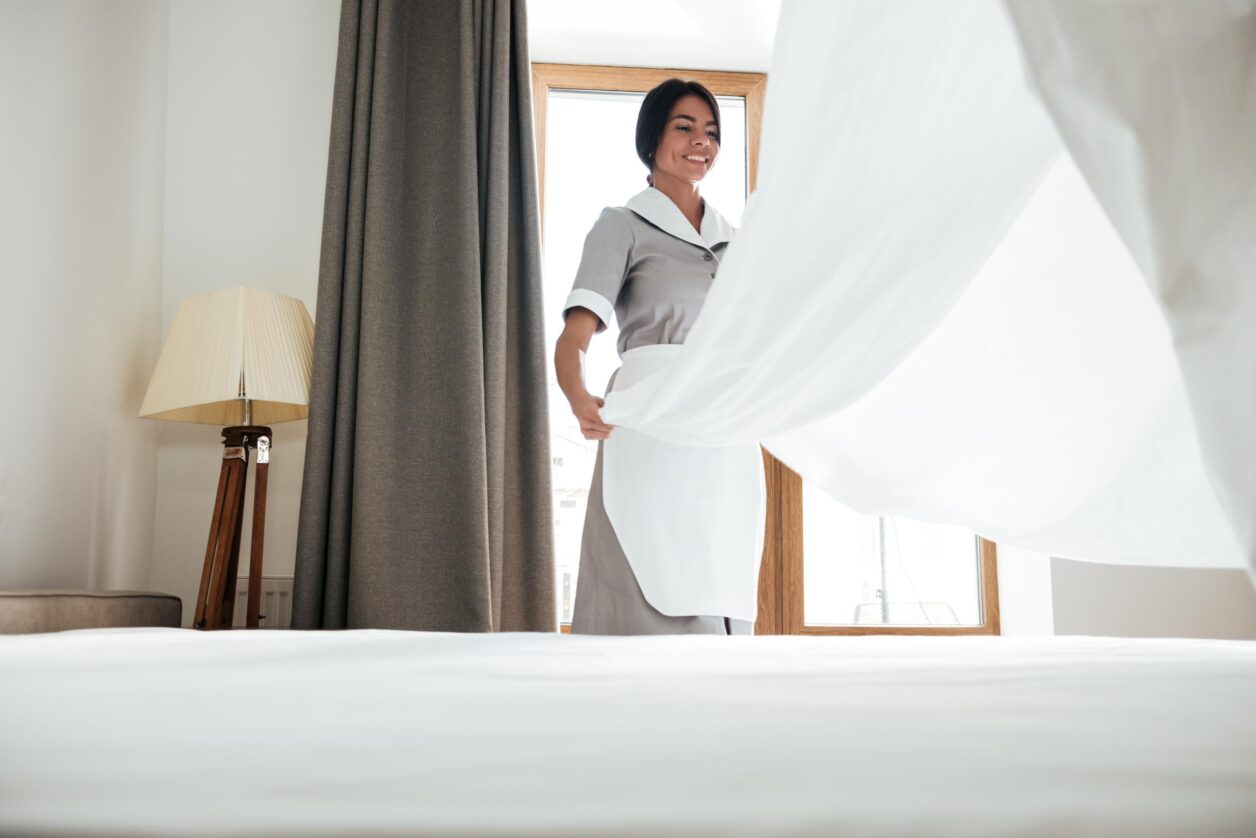 housekeeper making the bed