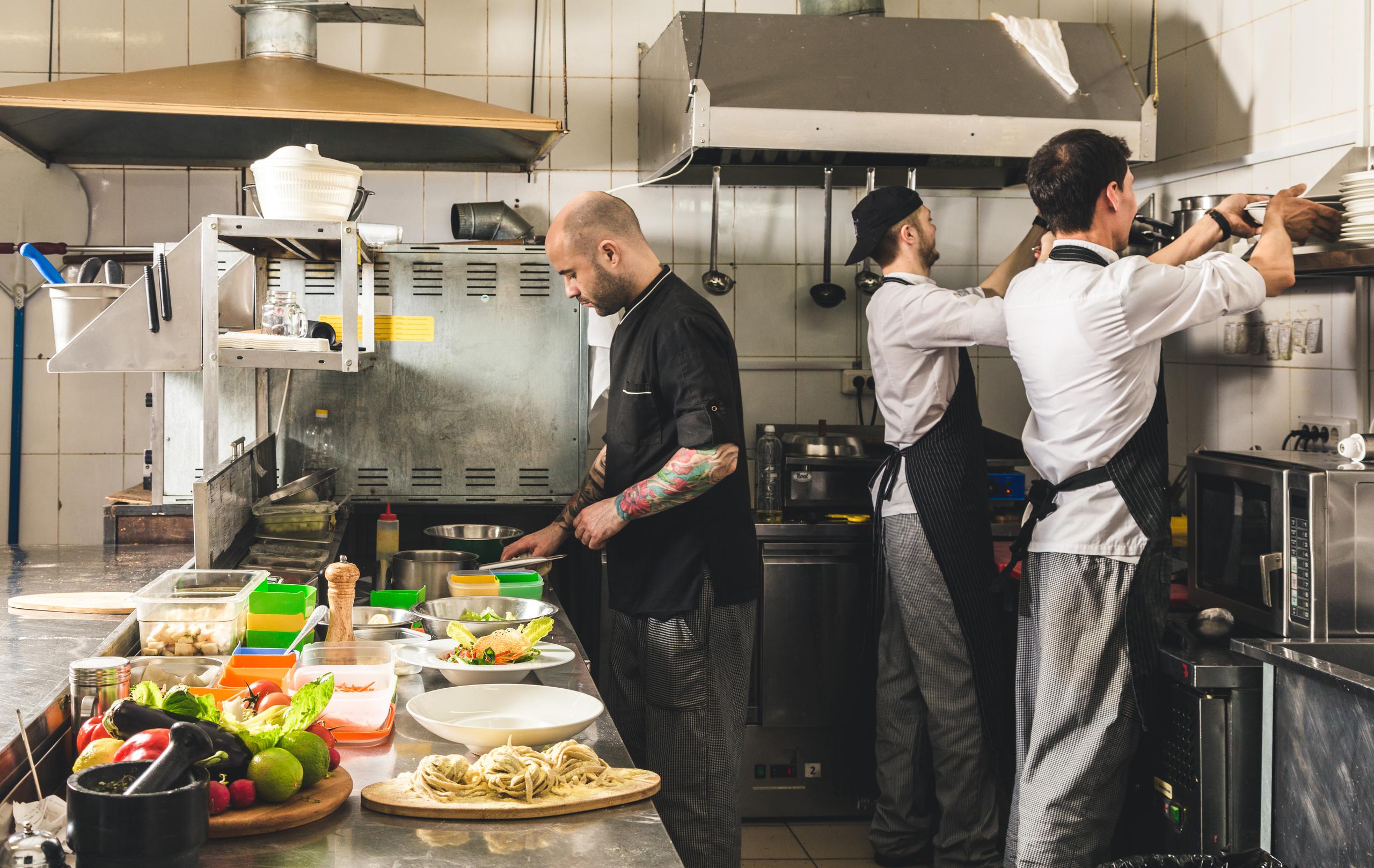 cooks preparing meals in commercial kitchen