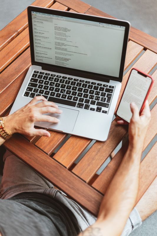 man working on laptop and phone