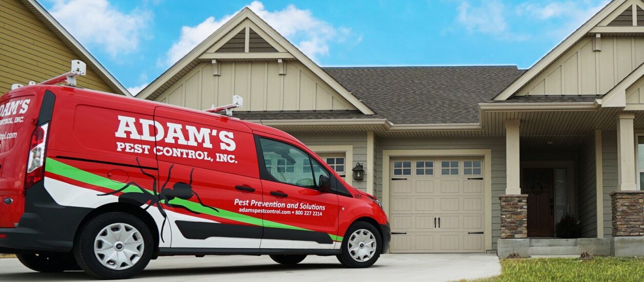 Adam's Pest Control van in front of home
