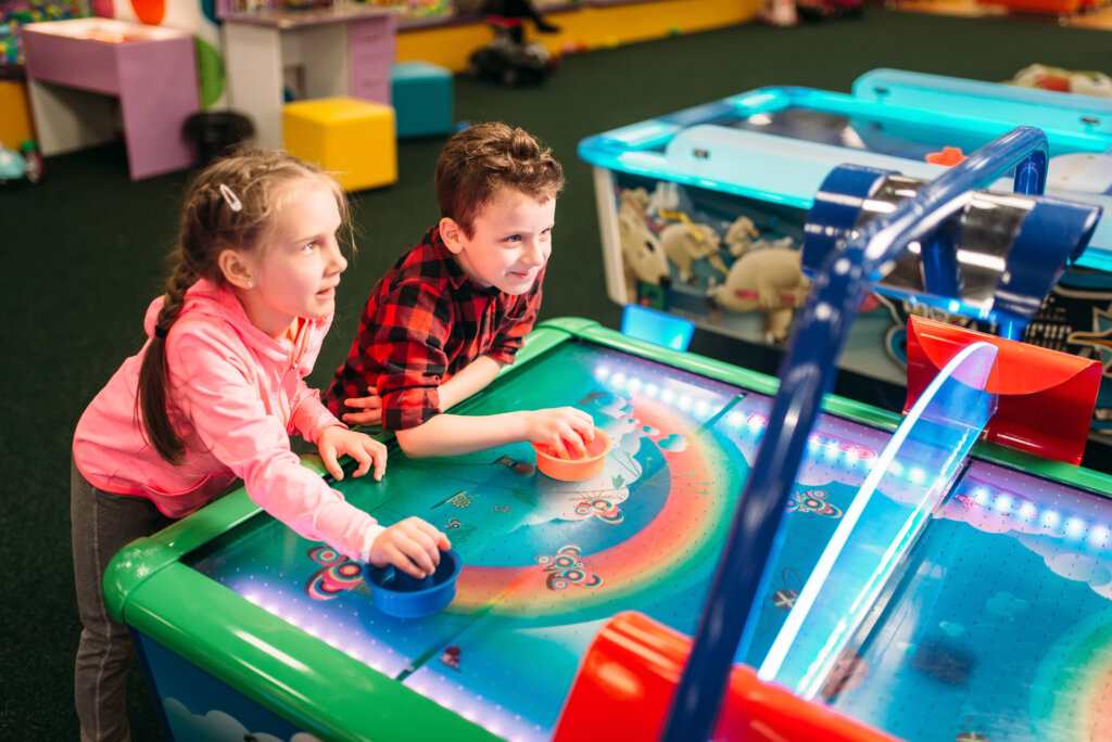 Two kids playing air hockey