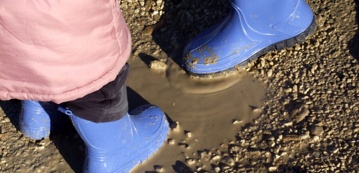 Kids' boots in mud puddle