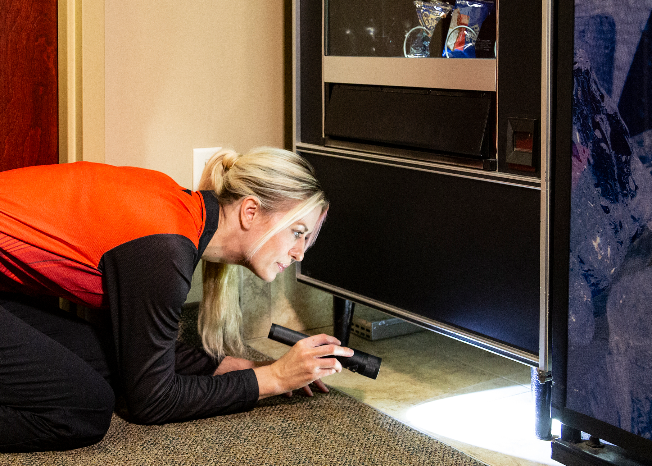 Technician Looking Under Vending Machine