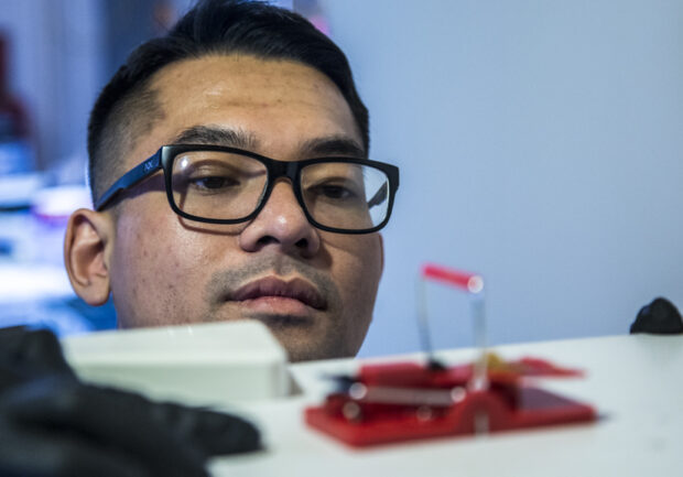 Licensed pest control technician inspecting mouse trap for rodent activity in Minnesota home.