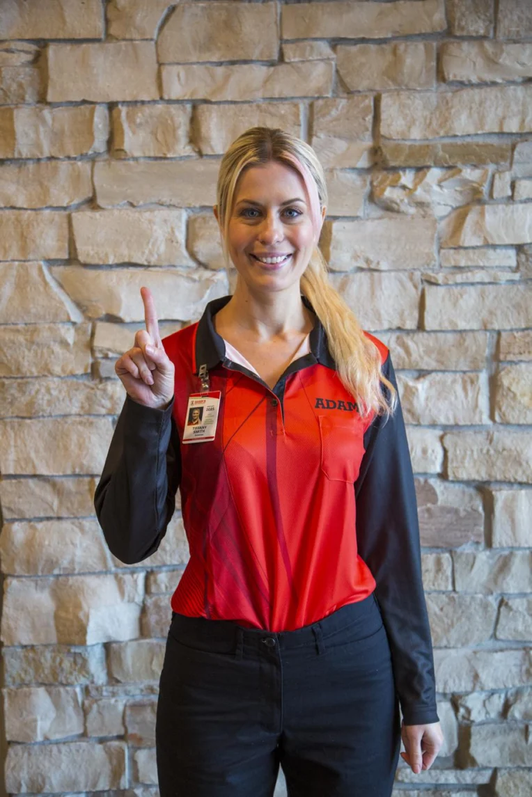 Adams Pest Control Lady Technician Smiling and pointing up.