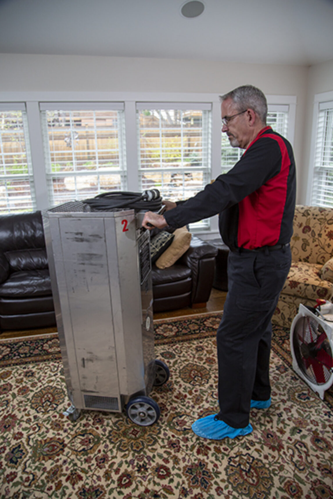 Technician setting up professional bed bug heat treatment equipment in a bedroom