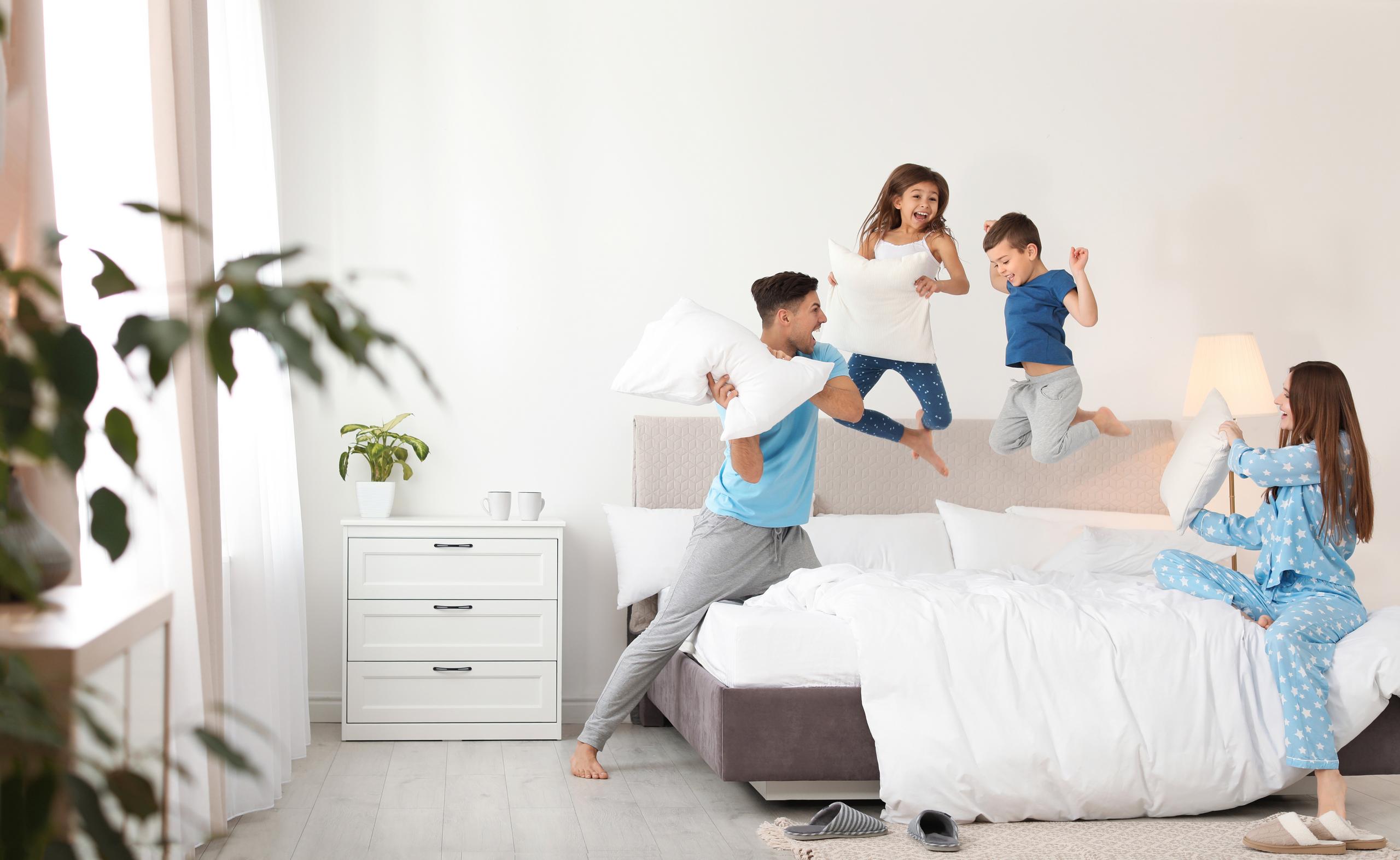 family jumping on bed