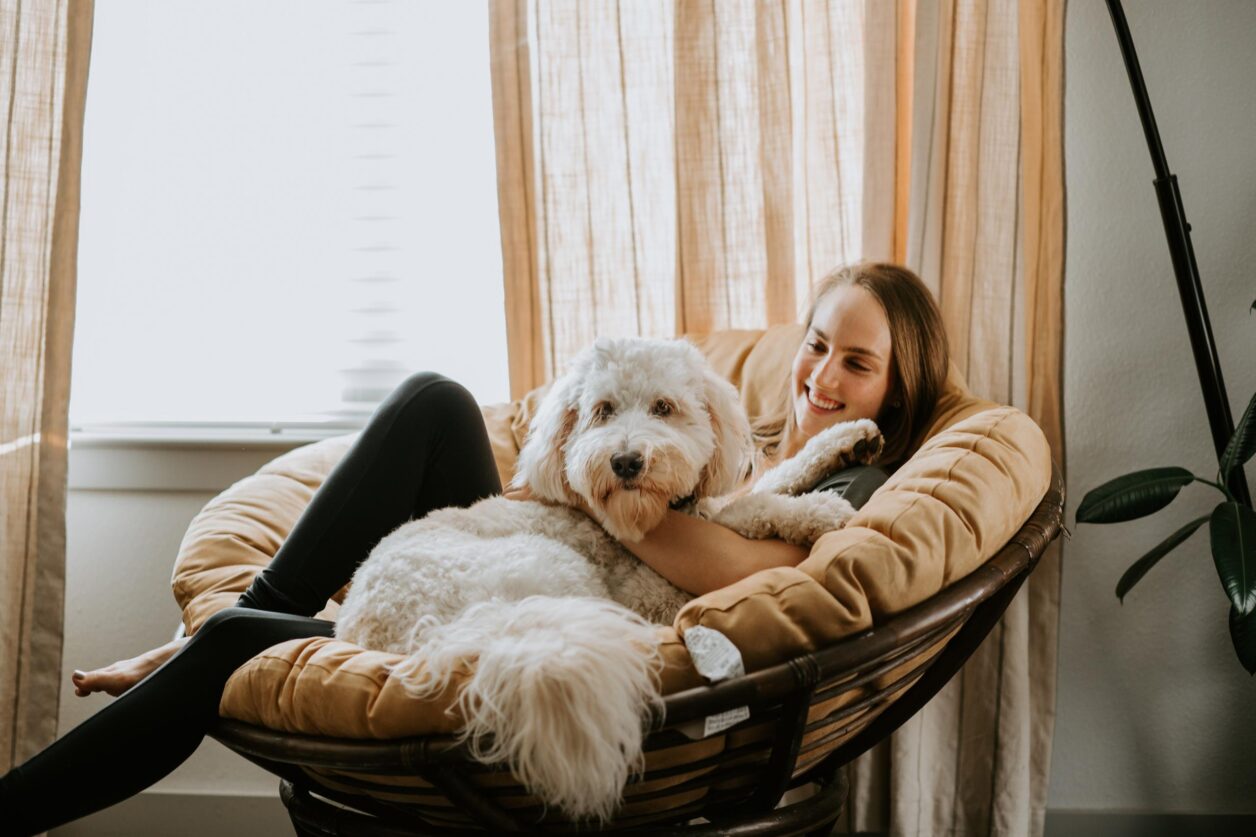 young woman and dog in papasan chair