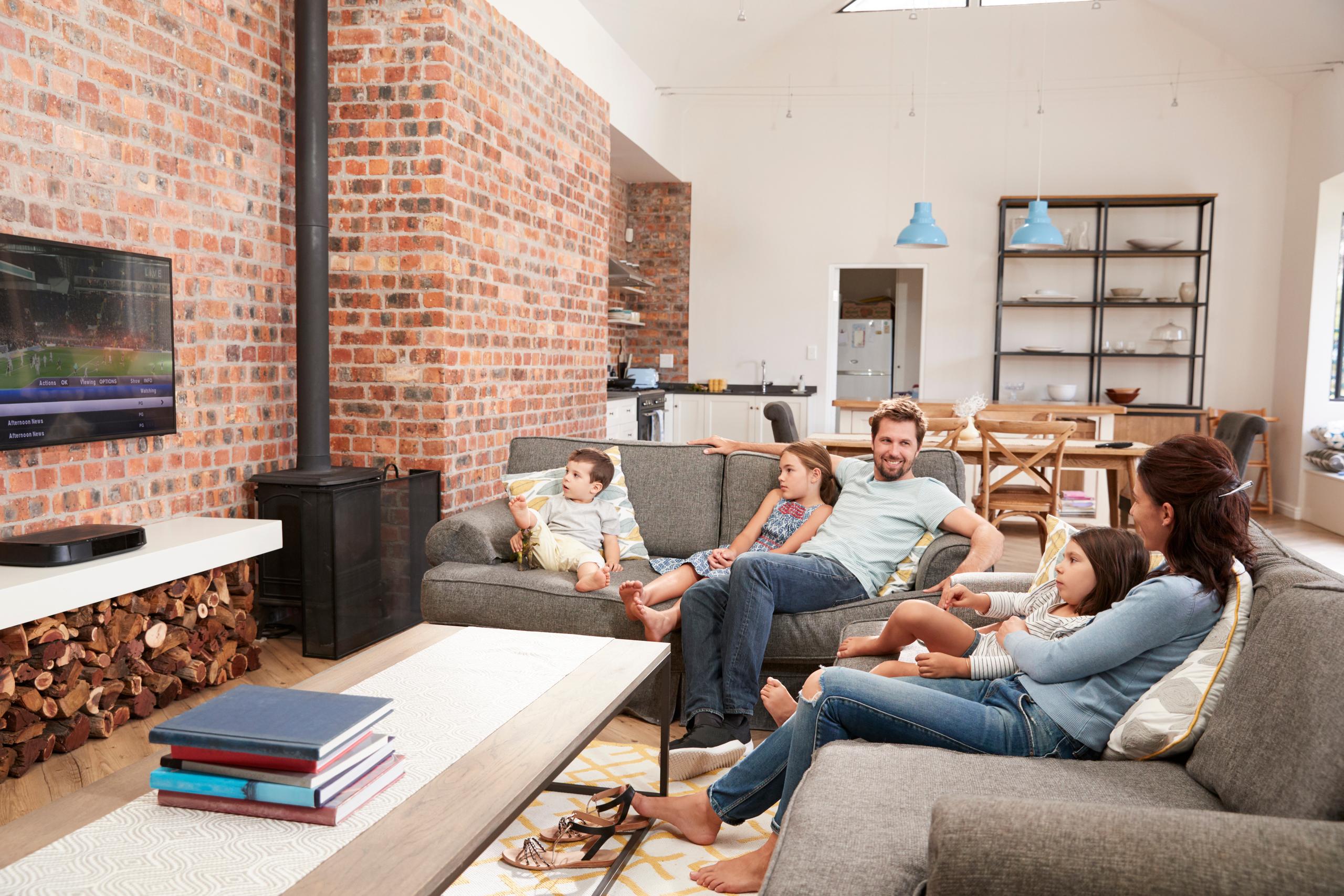 family sitting on couch watching television