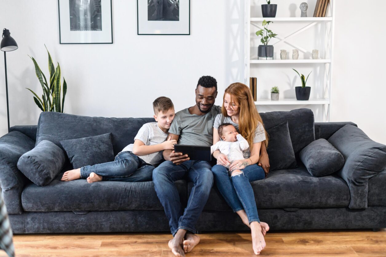 family on couch looking at tablet